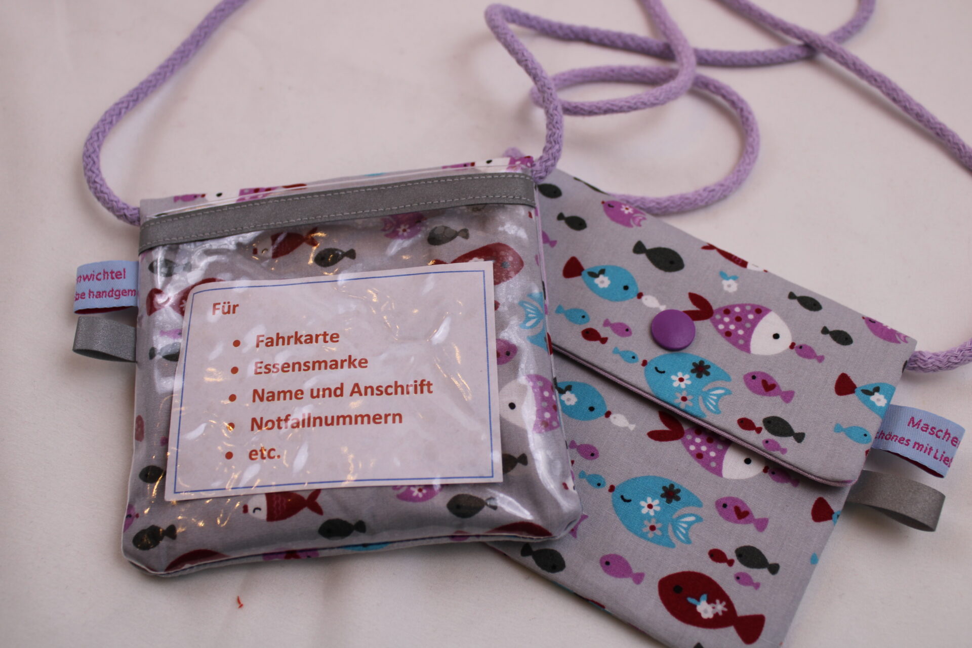 Kinder-BRUSTBEUTEL "Bunte Fische" mit Druckknopf, Reflektorfähnchen; mit oder ohne Klarsichtfach/Fahrkartenfach, Brusttasche, Geldbörse Kinder-BRUSTBEUTEL "Bunte Fische" mit Druckknopf, Reflektorfähnchen; mit oder ohne Klarsichtfach/Fahrkartenfach, Brusttasche, Geldbörse
