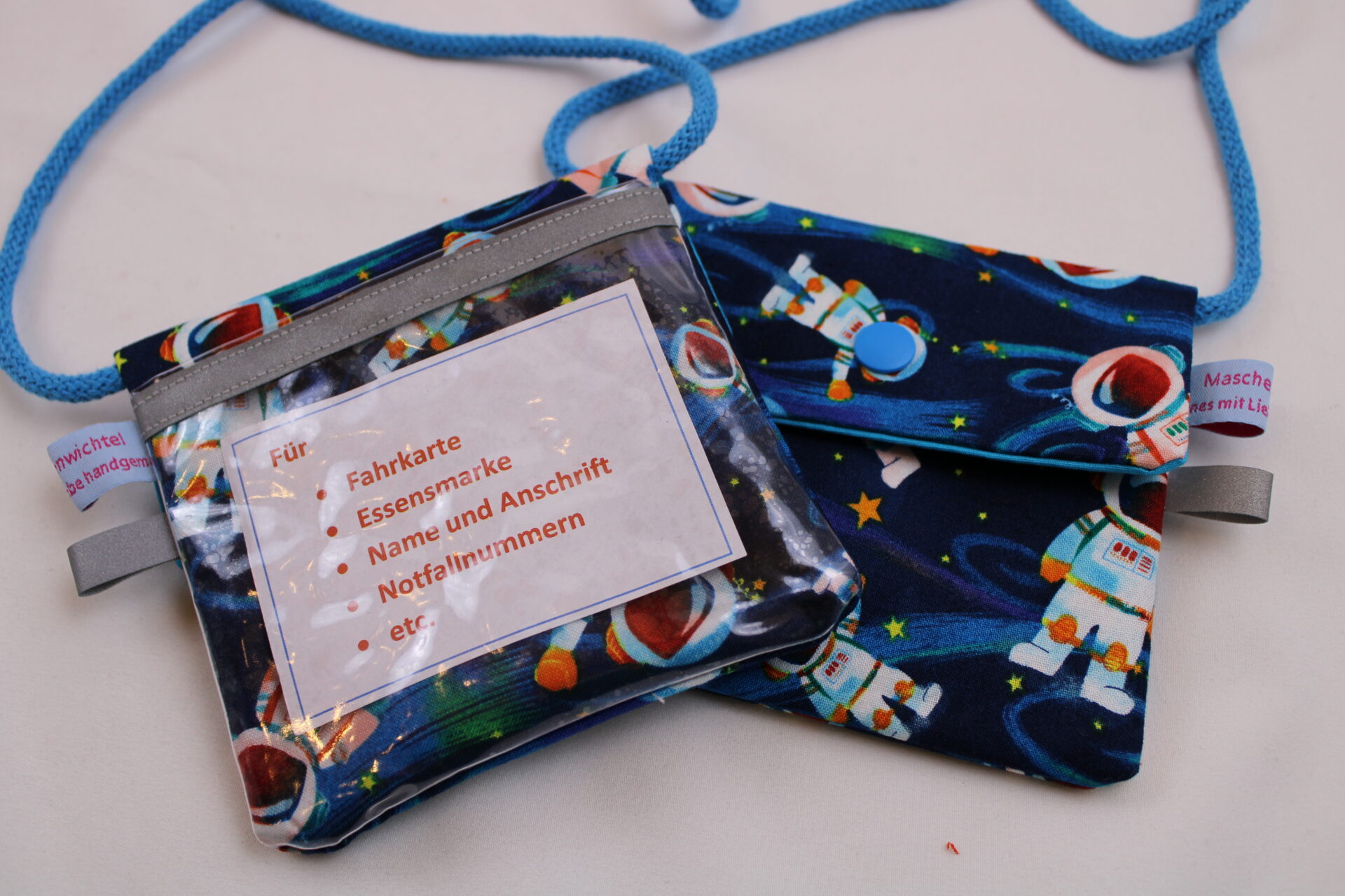 Kinder-BRUSTBEUTEL "Astronaut im All" mit Druckknopf, Reflektorfähnchen; mit oder ohne Klarsichtfach/Fahrkartenfach, Brusttasche, Geldbörse Kinder-BRUSTBEUTEL "Astronaut im All" mit Druckknopf, Reflektorfähnchen; mit oder ohne Klarsichtfach/Fahrkartenfach, Brusttasche, Geldbörse